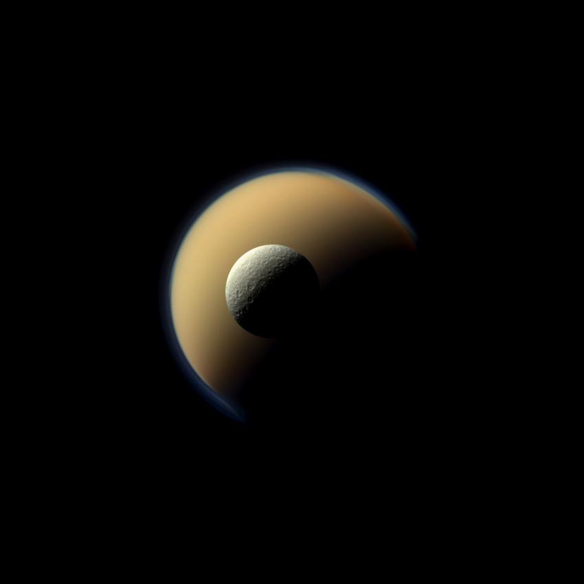 Saturn's largest and second largest moons, Titan and Rhea, appear to be stacked on top of each other in this true-color scene. Credit: NASA/JPL-Caltech/Space Science Institute