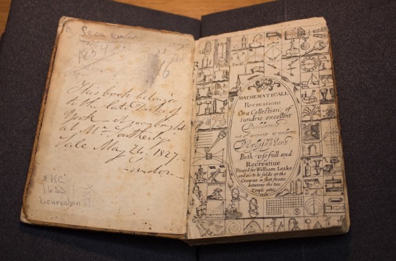 wide shot of yellowed title page of book with surrounding illustrations