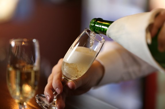 someone pouring champagne into a flute glass