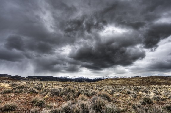 a dark cloudy sky over a desert landscape