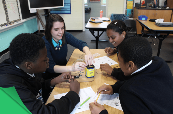 four kids in a classroom sitting at a table
