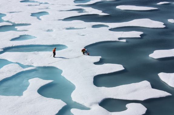 sheets of ice and water two people sampling and gathering equipment