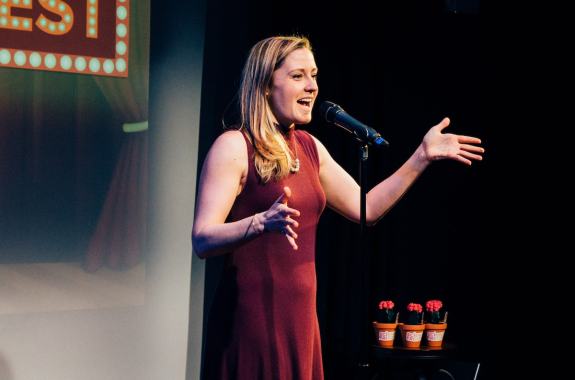 woman at a microphone speaking to an audience