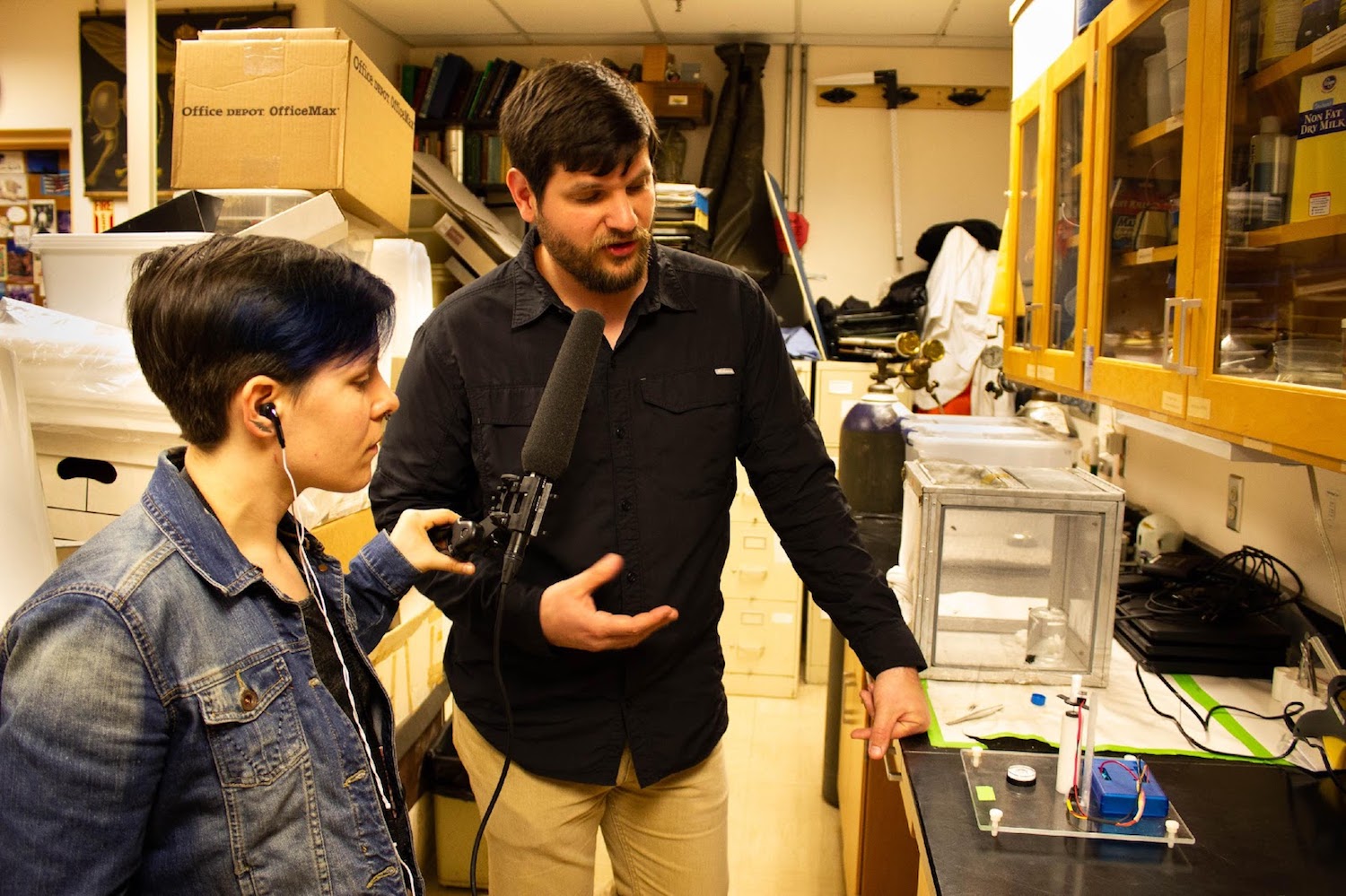 taylor holding a microphone to gantz in the lab