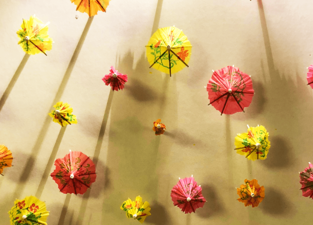 a bunch of brightly colored red, yellow, and orange umbrellas covering a white board
