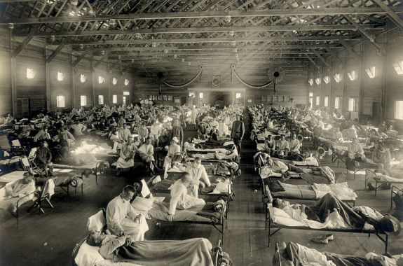 black and white photo of overflowing hospital ward filled with cots and patients