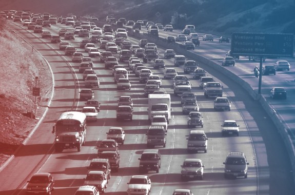 a curved highway clogged with cars and other vehicles. a red and blue overlay is on top of the entire photo