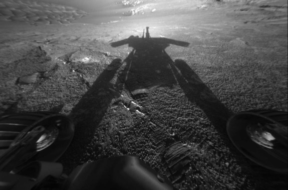 a black and white photo of the shadow of a rover on the dunes of mars