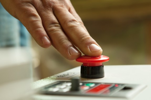 hand pressing down on big red button