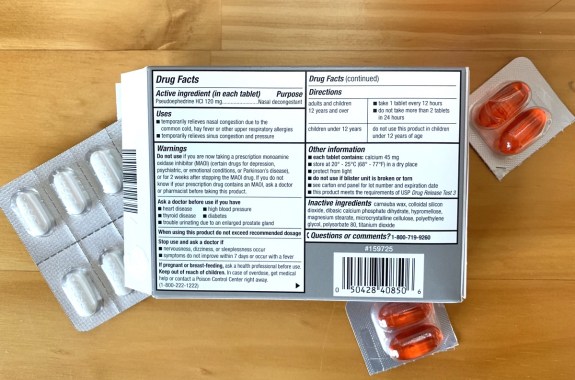 the backside of a carton of medication, listing the directions, side effects, and inactive ingredients. the box is surrounded by different colored pills
