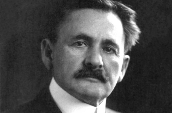a black and white photo of a white older man with a thick mustache