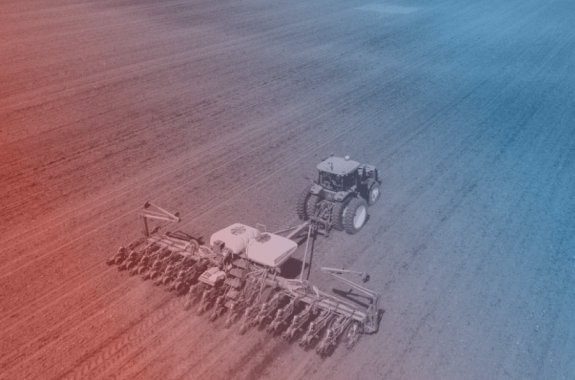 a tractor with a large and wide till travels across a dirt field