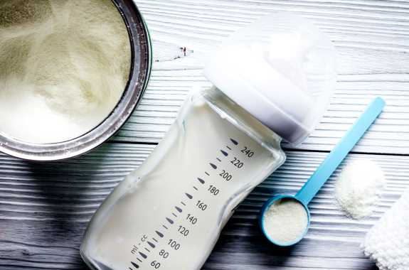 Preparation of baby formula on wooden background top
