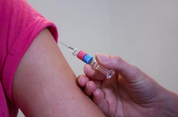 Child's arm receiving a vaccine