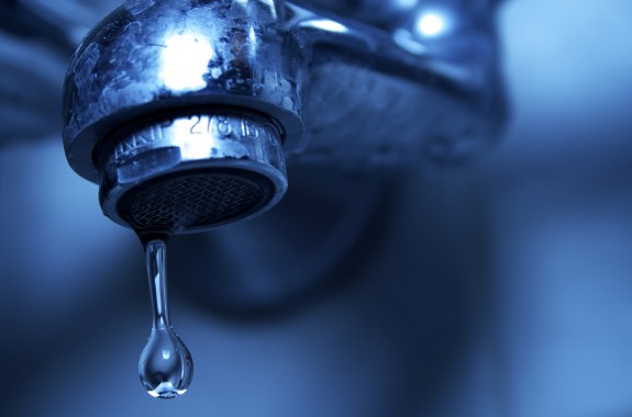 Pluma de metal con agua, con un fondo abstracto