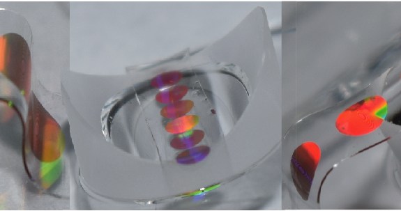 three different shots of an iridescent circle on a clear pliable, bending substrate
