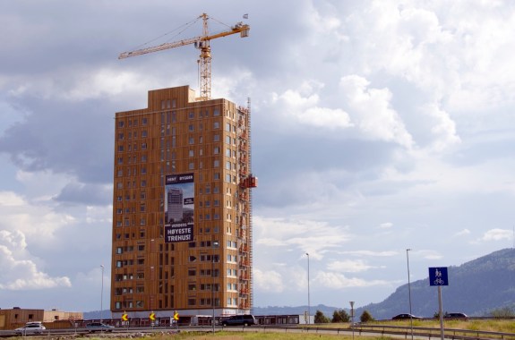 An 18-story tall wood building with a crane above it