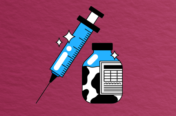 bottle filled with cow colored liquid and syringe on red background