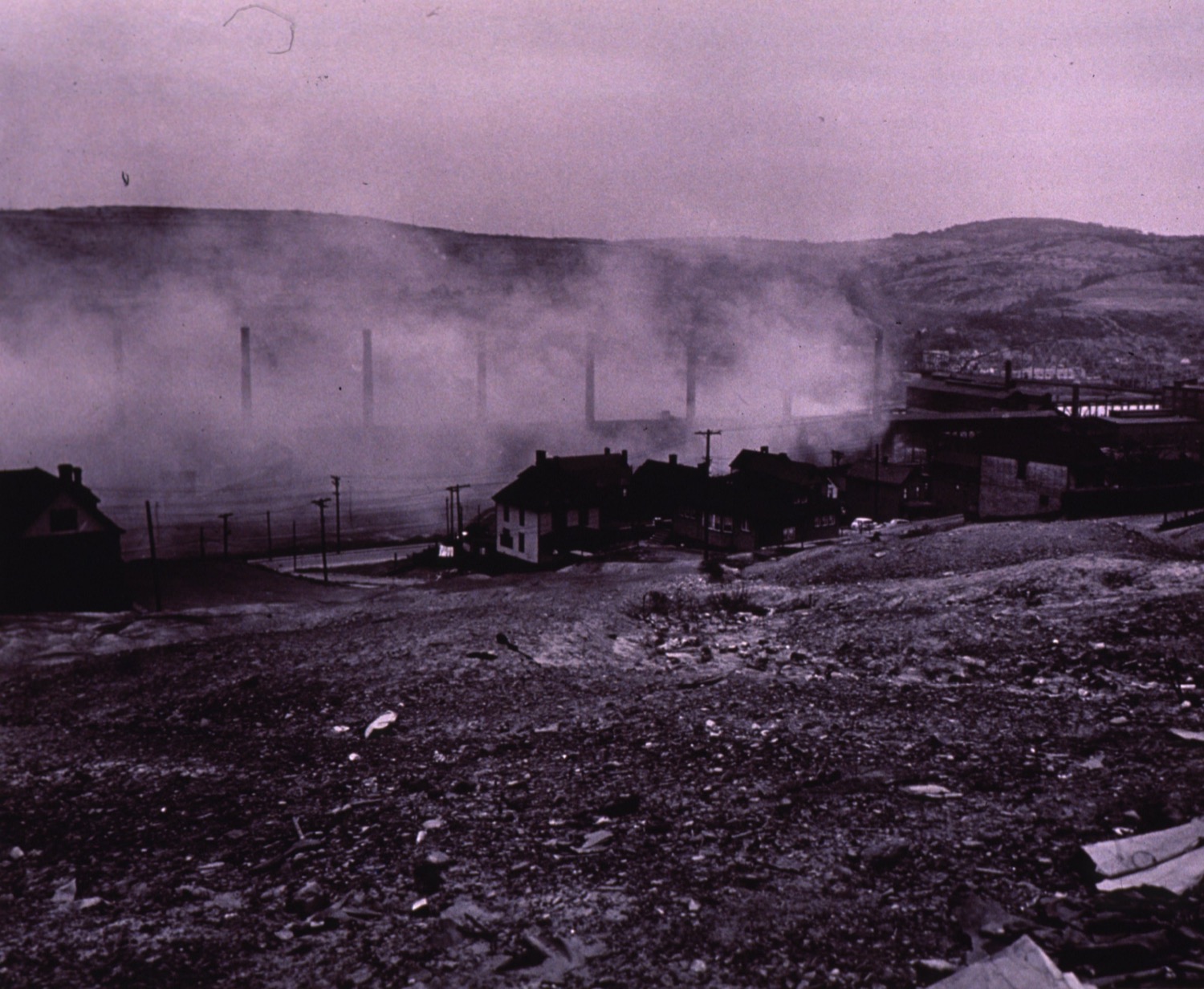 smoke stacks can faintly be seen through a thick smog