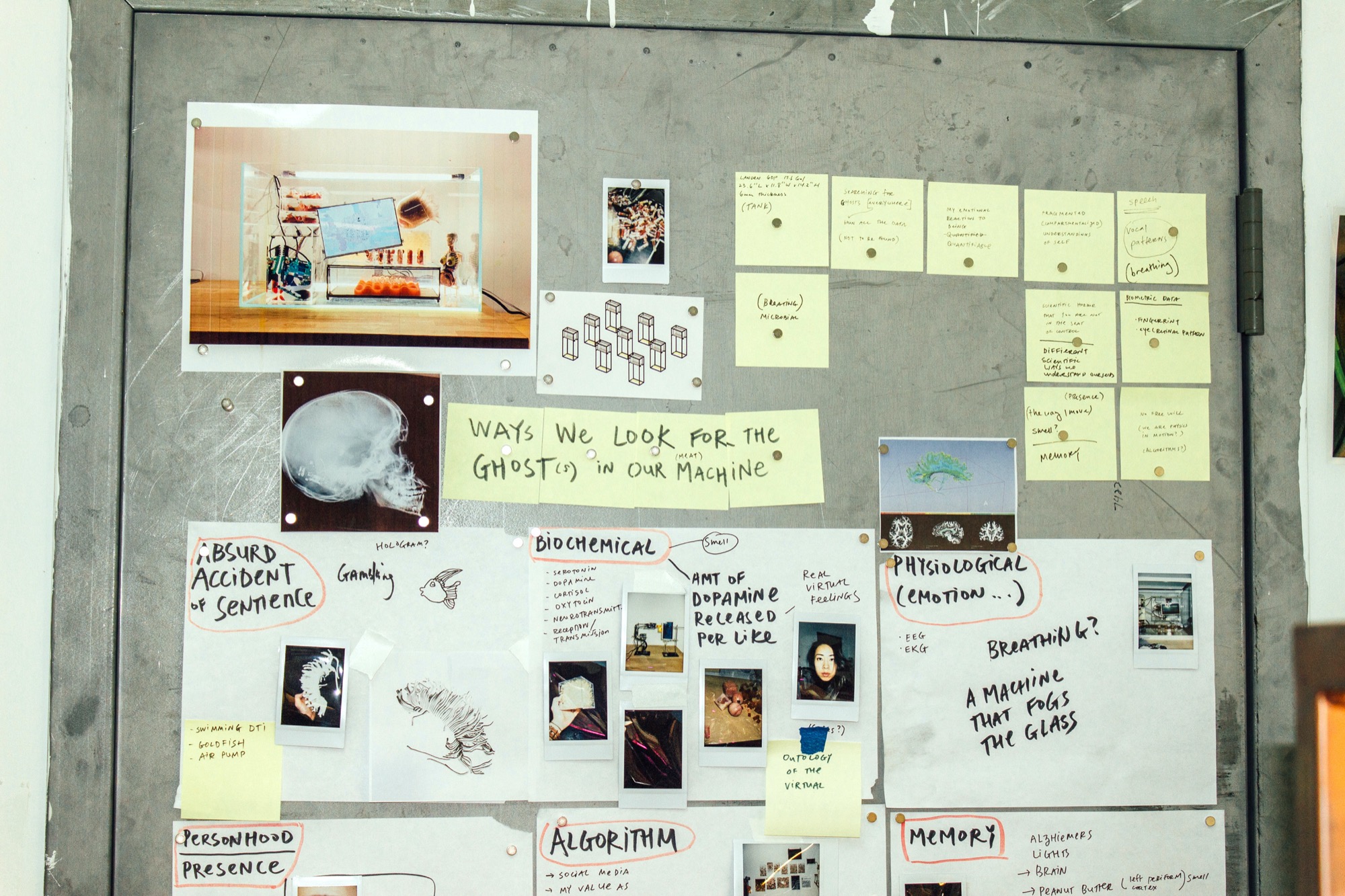 a wall filled with post it notes, printed out images, paper, with ideas about AI, ghosts in the machine