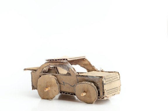 A small car made out of cardboard on a white background
