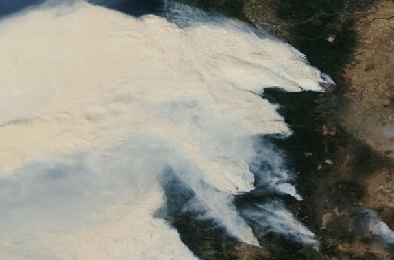 a satellite view of huge billows of smoke over oregon and the pacific northwest coast