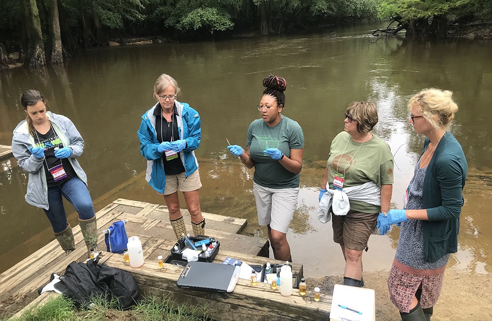 a group of people standing next to a river