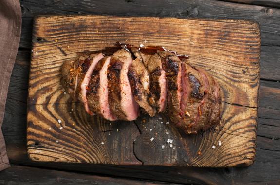 cooked beef cut up on cutting board