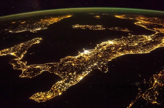 italy from space at night, with millions of lights shining