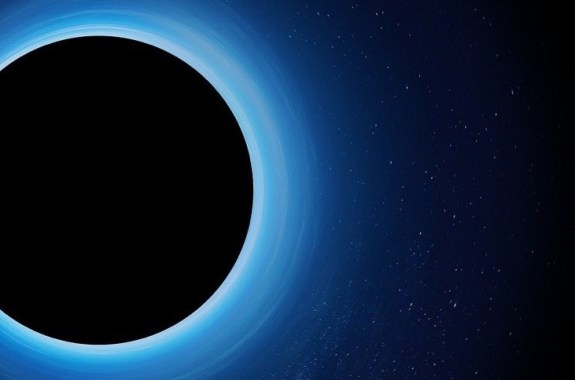 a computer simulation of a black hole, showing a circle in a blue ring and a pitch black center. stars can faintly be seen around the circle
