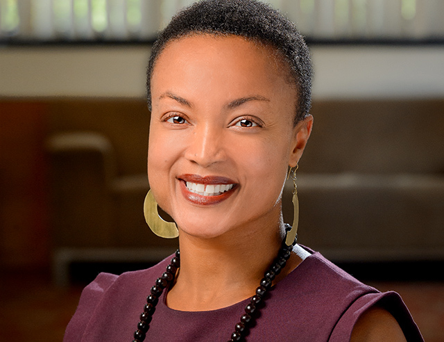 a Black woman smiling at the camera