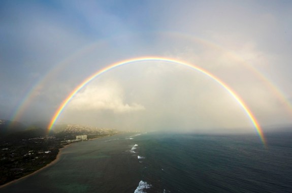 a double rainbow over the coastline of an island