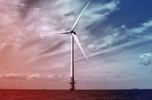a wind turbine in the ocean that is filtered red and blue