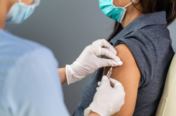 close up doctor holding syringe and using cotton before make injection to patient in medical mask.