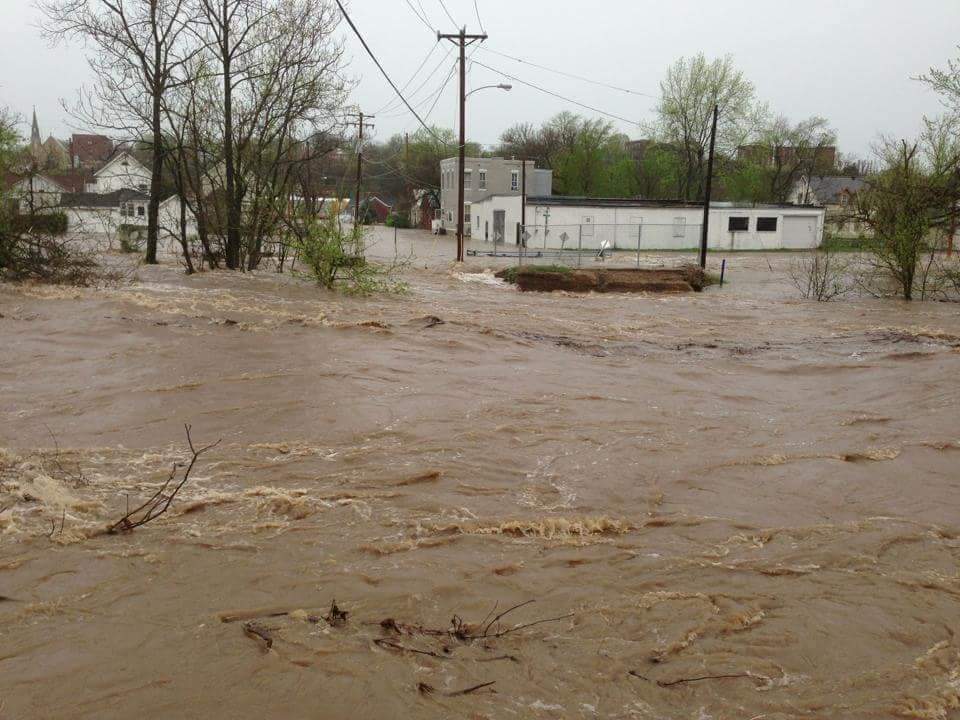 rushing brown water flooding buildings