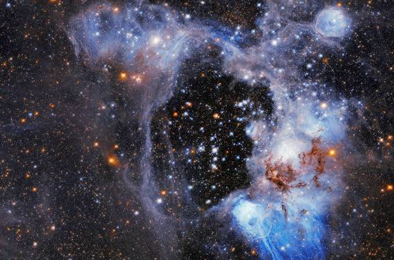 colorful cluster of stars and twinkling lights with purples, oranges, whites all swirling together