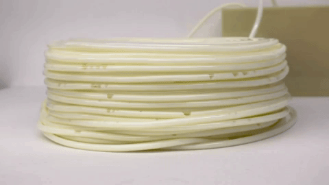 synthetic milk pulsing through a stacked coil of tubes on a white background