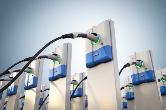 a 3d photo-real rendering of a dozen or so electric vehicle chargers, placed in three rows