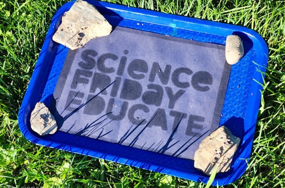 A bleached piece of black construction paper with words that read “Science Friday Educate”