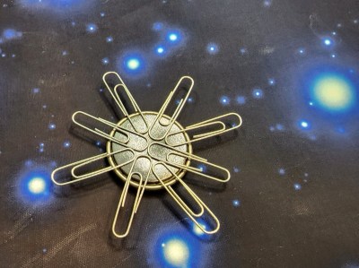 A magnet and paperclips arranged to look like the Sun.