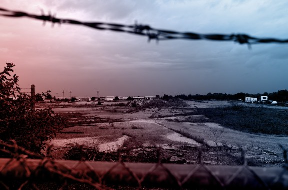 Looking through barbed wire, the landscape of the defunct Litton Industries site