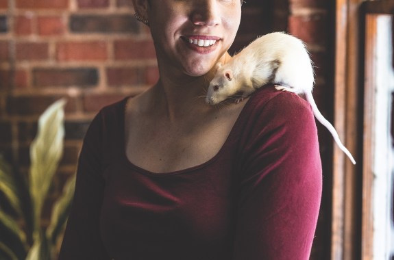 A woman with a rat on her shoulder.