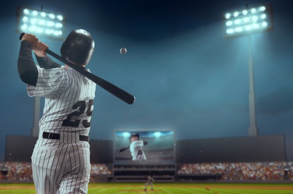 Baseball player bats the ball on professional baseball stadium