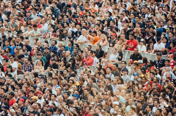 A multicultural crowd cheering in the stadium at a football game.
