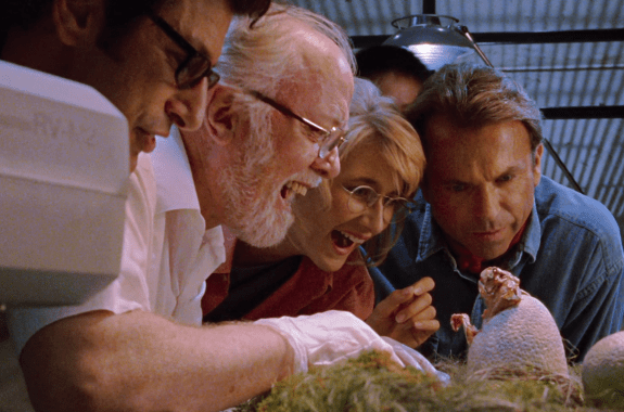 Ellie (Laura Dern) and Grant (Sam Neill) watch a baby raptor hatch in "Jurassic Park."