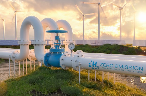 A pipe that reads "H2 Zero emission" with wind turbines in the background.