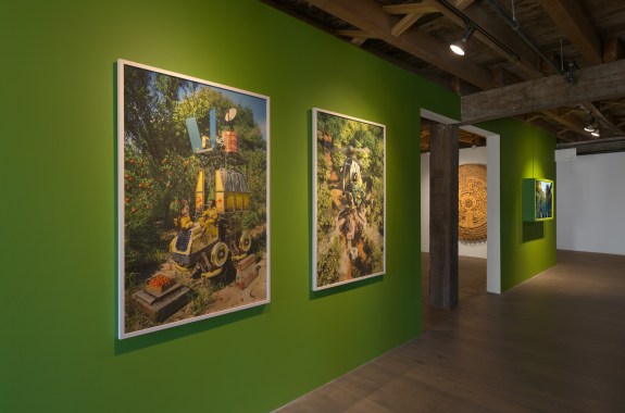 A green wall adorned with paintings of gardens and garden tools.