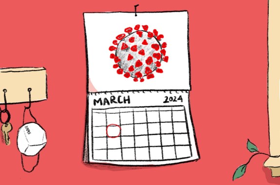 A calendar with the COVID-19 virus on it. Next to it hangs a KN95 mask.
