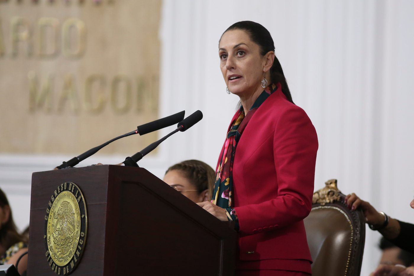 A woman, Claudia Sheinbaum Pardo, stands at a podium giving a speech.