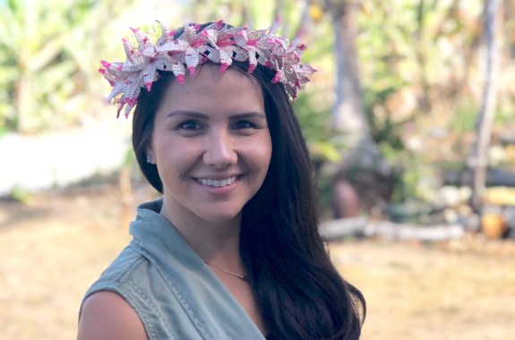 A woman wearing a floral headband looks at the camera.